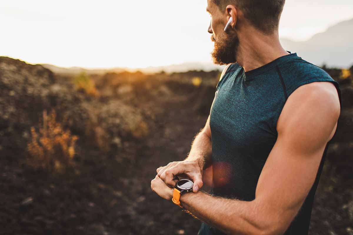 A man checking his fitness tracker - how long does it take to run a mile