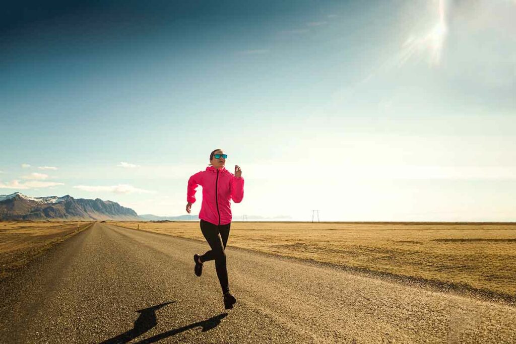 Female runner doing fartlek training on a road